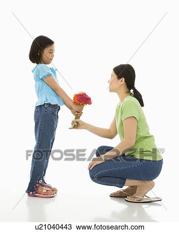 Girl handing bouquet of flowers to her mother View Large Photo Image Stock Image - Girl handing bouquet of flowers to her mother. Fotosearch