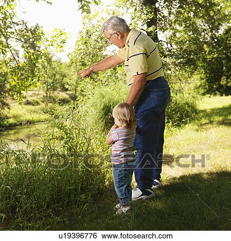 Grandfather holding granddaughter's hand by creek and pointing View Large Photo Image Stock Photograph - Grandfather holding granddaughter's hand by creek and pointing. Fotosearch