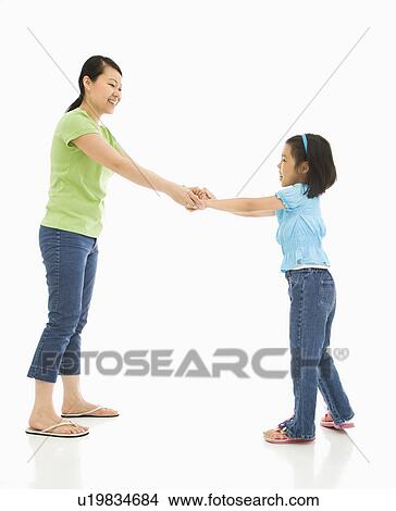 Picture - Mother and daughter playing together holding hands. Fotosearch