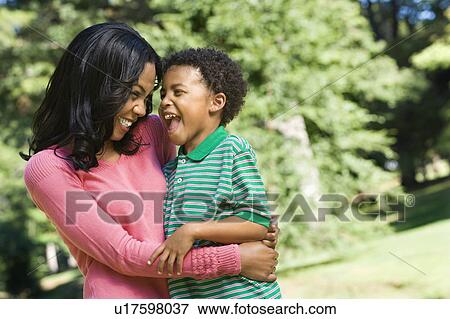 Stock Photo - Mother holding young son looking into eachother's eyes and smiling.. Fotosearch