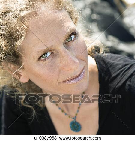 Stock Photo - Caucasian mid-adult woman with wavy hair looking at viewer.. Fotosearch