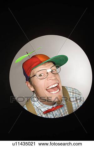 Close up circle vignette of Caucasian young man dressed like nerd wearing propeller cap with mischievous look. View Large Photo Image Stock Image - Close up circle vignette of Caucasian young man dressed like nerd wearing propeller cap with mischievous look.. Fotosearch