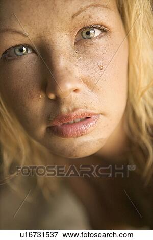 Stock Photo - Close-up of blond womans muddy face looking at viewer.. Fotosearch