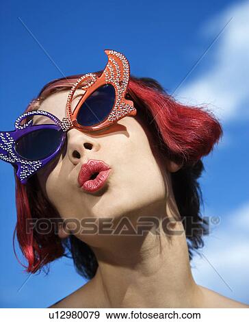 Stock Photo - Close up of young adult Caucasian female wearing unique vintage glasses.. Fotosearch