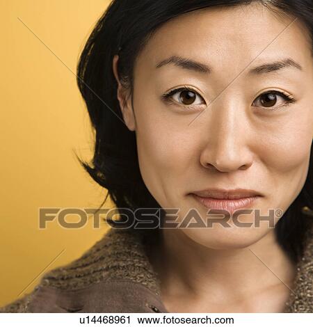 Stock Image - Close up portrait of mid adult Asian woman.. Fotosearch