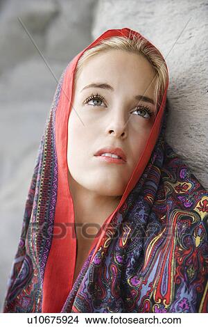 Picture - Portrait of Caucasian young adult woman with scarf draped over head looking up.. Fotosearch