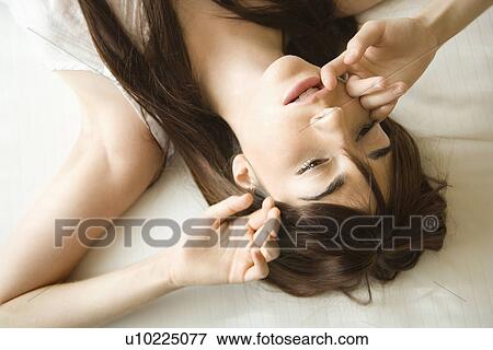 Pretty young Caucasian woman lying on bed wearing nightgown. View Large Photo Image Stock Photo - Pretty young Caucasian woman lying on bed wearing nightgown.. Fotosearch