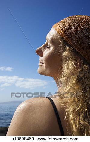 Profile of Caucasian mid-adult woman with wavy hair and head scarf at coast. View Large Photo Image Stock Photo - Profile of Caucasian mid-adult woman with wavy hair and head scarf at coast.. Fotosearch