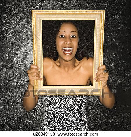 Stock Photo - Woman holding frame over her face. Fotosearch