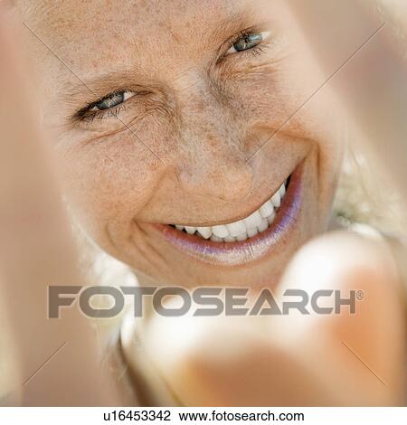 Woman smiling and gesturing at viewer View Large Photo Image Stock Image - Woman smiling and gesturing at viewer. Fotosearch