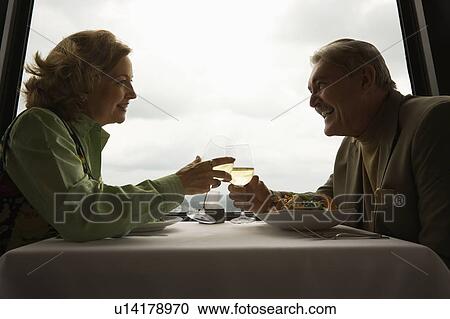 Caucasian mature couple at nice restaurant drinking wine and talking and laughing. View Large Photo Image Stock Image - Caucasian mature couple at nice restaurant drinking wine and talking and laughing.. Fotosearch
