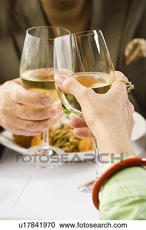 Caucasian mature couple toasting with white wine in restaurant. View Large Photo Image Stock Image - Caucasian mature couple toasting with white wine in restaurant.. Fotosearch
