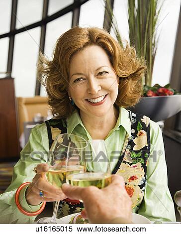Caucasian mature couple toasting with white wine in restaurant. View Large Photo Image Stock Photography - Caucasian mature couple toasting with white wine in restaurant.. Fotosearch