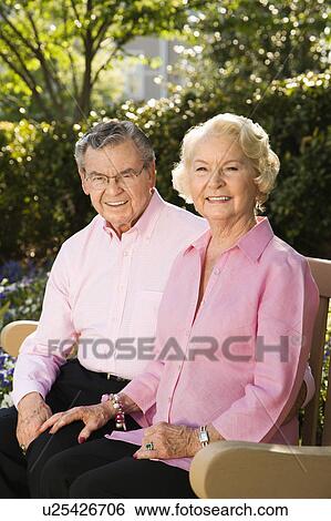 Couple sitting on bench View Large Photo Image Stock Photograph - Couple sitting on bench. Fotosearch