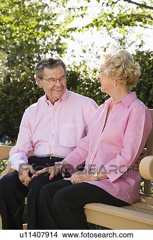 Couple sitting together on bench View Large Photo Image Picture - Couple sitting together on bench. Fotosearch