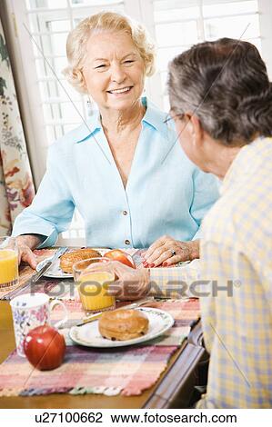 Stock Image - Mature Caucasian couple having breakfast together.. Fotosearch