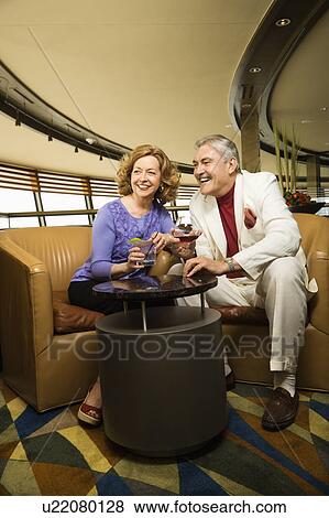 Mature Caucasian couple sitting in bar lounge having drinks and smiling. View Large Photo Image Stock Photo - Mature Caucasian couple sitting in bar lounge having drinks and smiling.. Fotosearch
