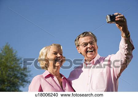 Mature Caucasian couple taking picture of themselves. View Large Photo Image Stock Image - Mature Caucasian couple taking picture of themselves.. Fotosearch