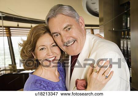 Stock Photo - Portrait of mature Caucasian couple embracing and smiling.. Fotosearch