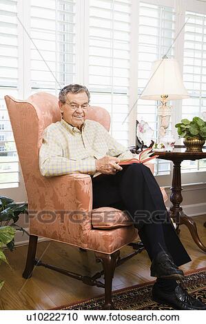Stock Image - Portrait of mature Caucasian man sitting in chair.. Fotosearch