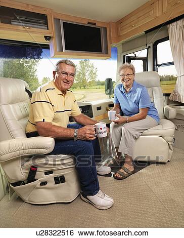 Senior couple sitting in RV holding coffee cups and smiling. View Large Photo Image Stock Photograph - Senior couple sitting in RV holding coffee cups and smiling.. Fotosearch