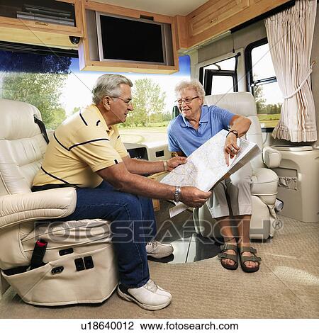 Senior couple sitting in RV looking at map and smiling. View Large Photo Image Stock Image - Senior couple sitting in RV looking at map and smiling.. Fotosearch