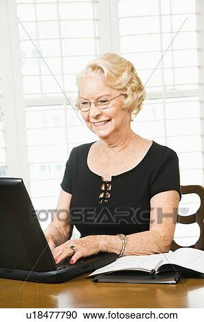 Senior woman using laptop in living room View Large Photo Image Stock Image - Senior woman using laptop in living room. Fotosearch