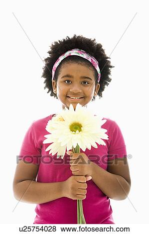 Stock Photo - African American girl holding large Gerbera Daisies smiling at viewer.. Fotosearch