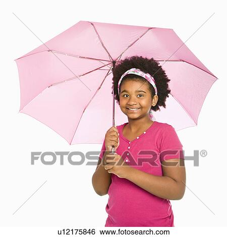 Stock Photograph - African American girl holding pink umbrella smiling at viewer.. Fotosearch