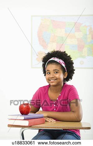African American girl sitting in school desk smiling at viewer. View Large Photo Image Stock Image - African American girl sitting in school desk smiling at viewer.. Fotosearch