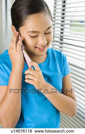 Stock Photo - Asian preteen girl talking on cell phone.. Fotosearch