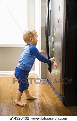 Caucasian toddler boy playing with magnets on refrigerator. View Large Photo Image Stock Image - Caucasian toddler boy playing with magnets on refrigerator.. Fotosearch