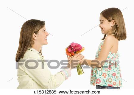 Stock Photography - Girl giving mother bouquet of flowers. Fotosearch