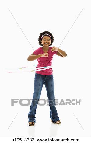 Stock Image - Girl playing with hula hoop and smiling at viewer. Fotosearch