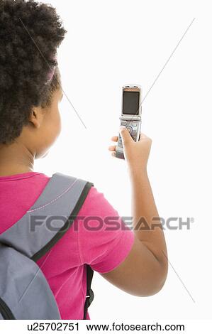 Stock Image - Girl with backpack looking at cell . Fotosearch