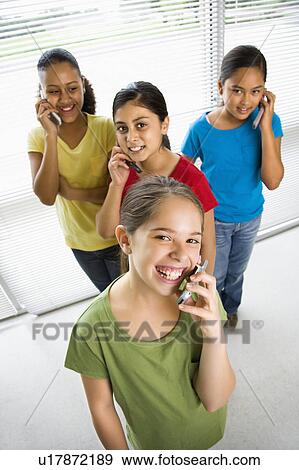 Stock Photo - Girls talking on cell phones. Fotosearch