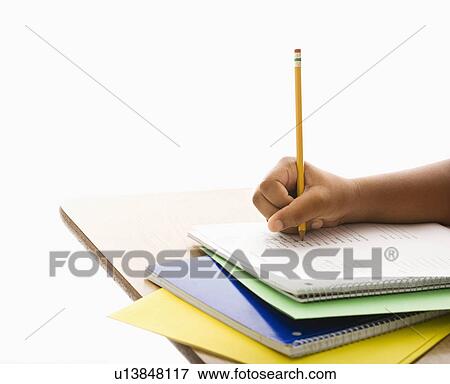 Hand of African American girl at school desk writing in notebook with pencil. View Large Photo Image Stock Photo - Hand of African American girl at school desk writing in notebook with pencil.. Fotosearch