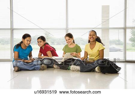 Preteen girls of mutiple ethnicities sitting together on floor with schoolwork smiling at viewer. View Large Photo Image Stock Photo - Preteen girls of mutiple ethnicities sitting together on floor with schoolwork smiling at viewer.. Fotosearch