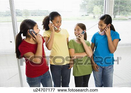 Stock Photo - Preteen girls of mutiple ethnicities talking on cell phones.. Fotosearch