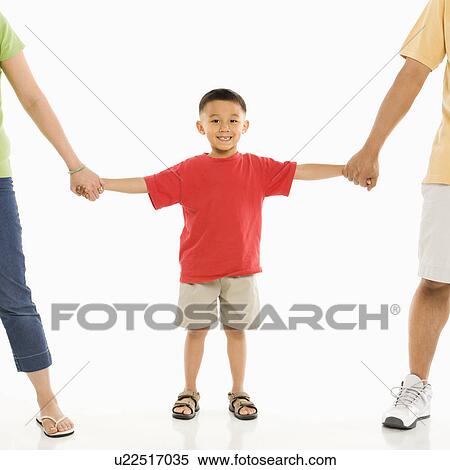 Stock Photography - Asian parents holding hands with son in front of white background.. Fotosearch