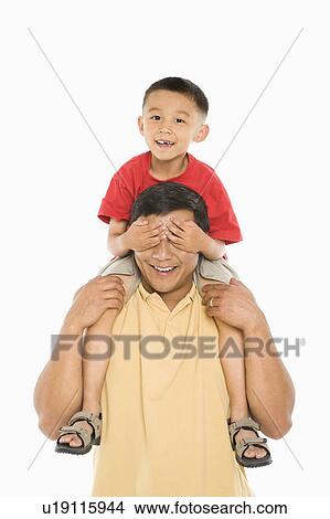 Picture - Boy sitting on father's shoulders . Fotosearch