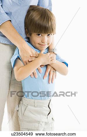 Stock Photo - Boy standing with mother against white background.. Fotosearch