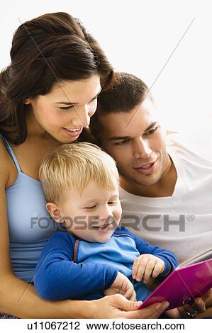 Caucasian parents and toddler son reading book together. View Large Photo Image Stock Image - Caucasian parents and toddler son reading book together.. Fotosearch