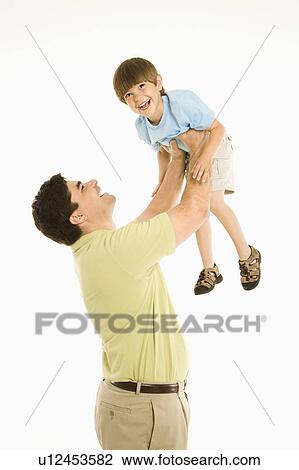 Stock Image - Father holding smiling son up overhead. Fotosearch