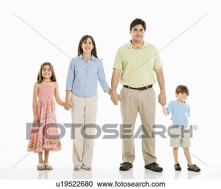 Stock Image - Hispanic family of four standing against white background holding hands.. Fotosearch
