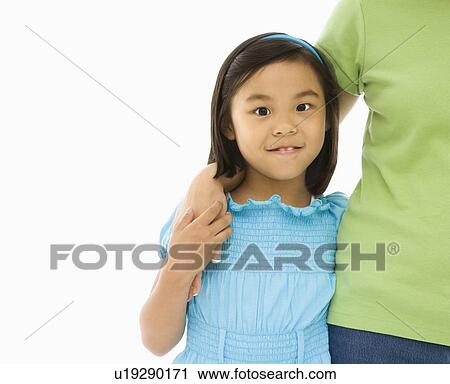 Stock Image - Mother and daughter standing with arms around each other. Fotosearch