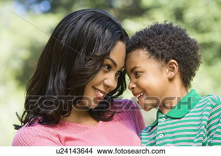 Picture - Mother holding young son looking into eachother's eyes and smiling.. Fotosearch