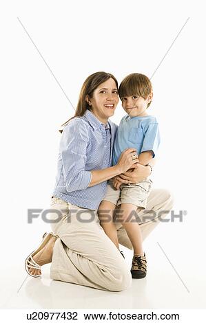 Stock Image - Mother kneeling down holding son . Fotosearch