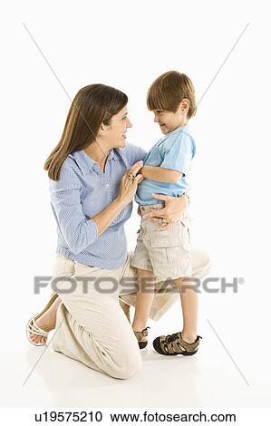 Stock Image - Mother kneeling down with son against white background.. Fotosearch