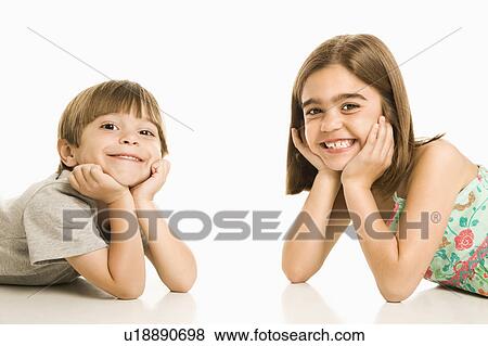 Stock Photo - Portrait of girl and boy smiling against white background.. Fotosearch